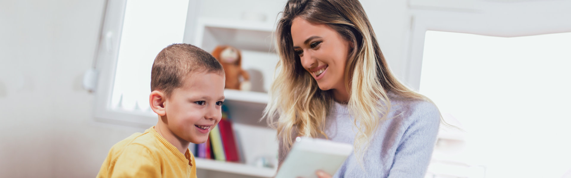 teacher and a boy using a tablet device